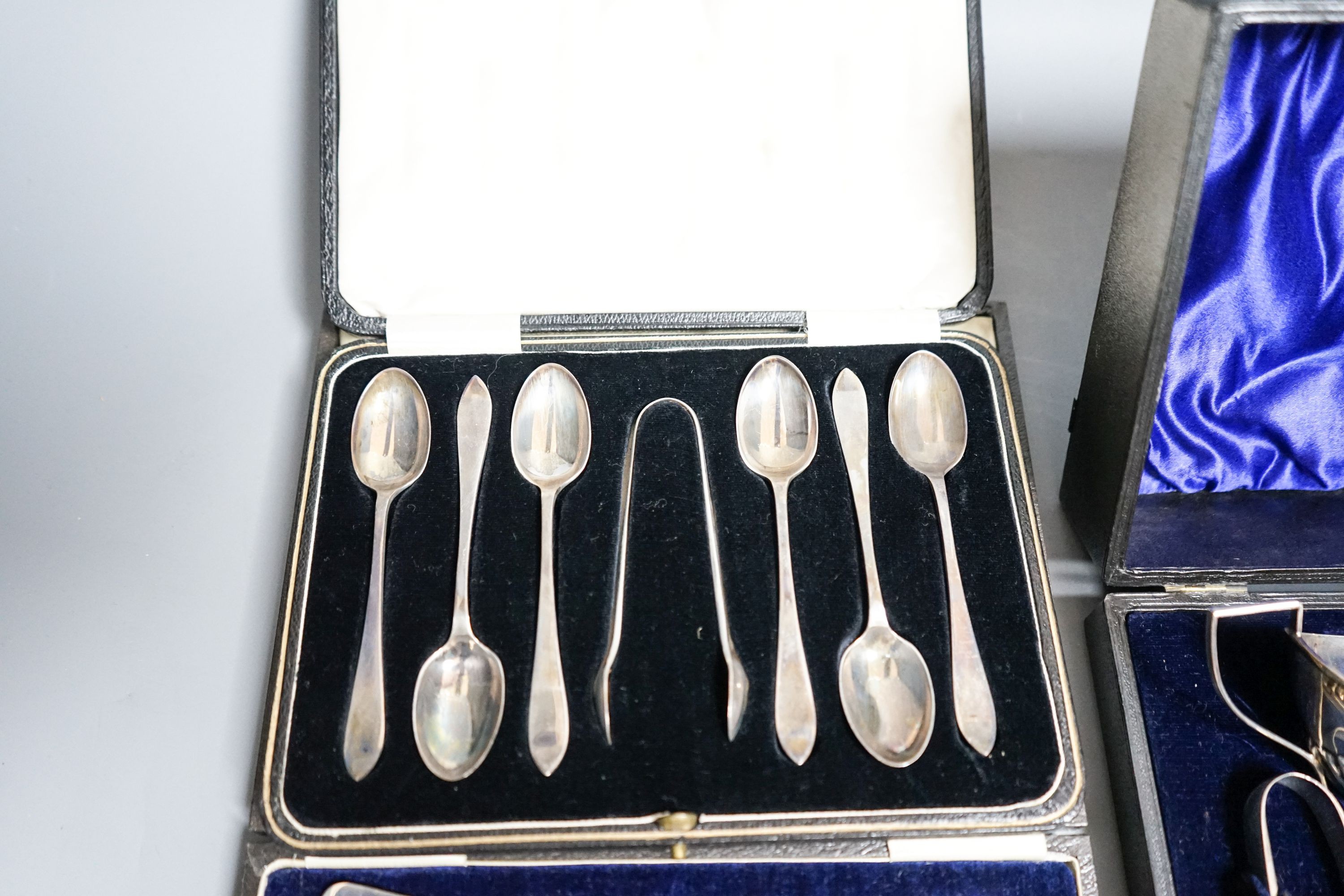 A cased Edwardian silver cream, sugar and sugar tongs, Birmingham, 1901 and two other cased sets of silver cutlery.